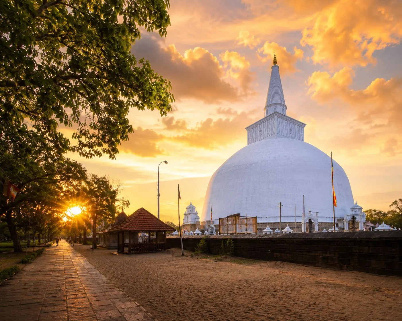 The great white Ruwanwelisaya stupa at Anuradhapura under a golden sunset sky